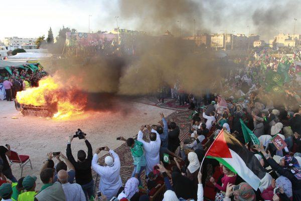 Jordanian supporters of the Muslim Brotherhood set fire to a mock Israeli tank during a protest to celebrate the 'Gaza victory' in the war against Israel, in the capital Amman, on Aug. 8, 2014. (Khalil Mazraawi/AFP/Getty Images)