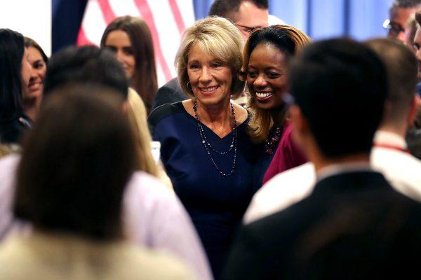 Education Secretary Betsy DeVos (C) poses for photographs with employees during her first day on the job at the Department of Education in Washington on Feb. 8, 2017. (Chip Somodevilla/Getty Images)