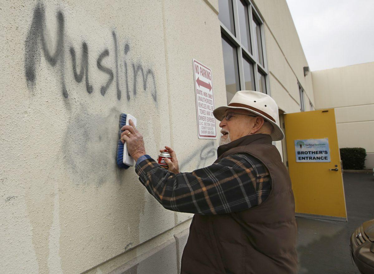 Tom Garing cleans up racist graffiti painted on the side of a mosque in what officials called an apparent hate crime in Roseville, Calif. on Feb. 1, 2017. (Rich Pedroncelli/AP Photo)