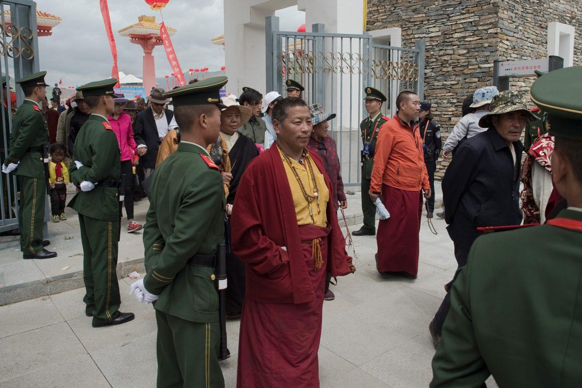 Chinese paramilitary police (in green uniforms) secure an exit as Tibetans monks (C) walk out from a stadium at the end of a local government-sponsored festival in the northwestern Chinese province of Qinghai in this file photo. (Nicolas Asfouri/AFP/Getty Images)