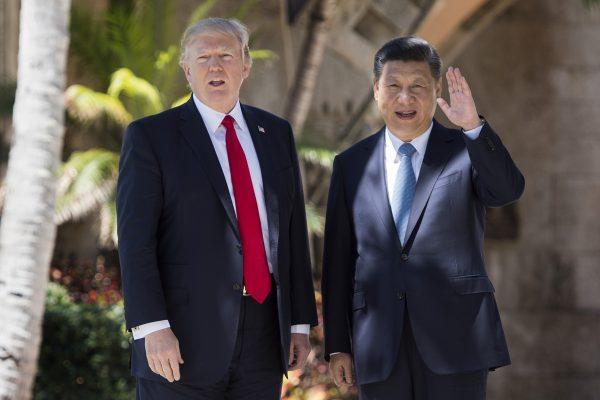 Chinese President Xi Jinping (R) waves to the press as he walks with US President Donald Trump at the Mar-a-Lago estate in West Palm Beach, Fla., on April 7, 2017. (Jim Watson/AFP/Getty Images)