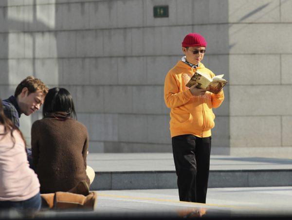 Xiao Jianhua, a Chinese-born Canadian billionaire, reads a book outside the International Finance Centre in Hong Kong in December 2013. (AP Photo/Next Magazine)