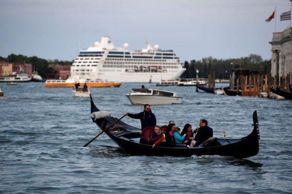 A cruise ship and a gondola with tourists navigate at the entrance of the Canale Grande (Grand Canal) in Venice, Italy, on April 7, 2017. (Miguel Medina/AFP/Getty Images)