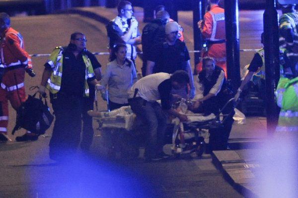 Police officers and members of the emergency services attend to a person injured in an apparent terror attack on London Bridge in central London on June 3, 2017. (Daniel Sorabji/AFP/Getty Images)