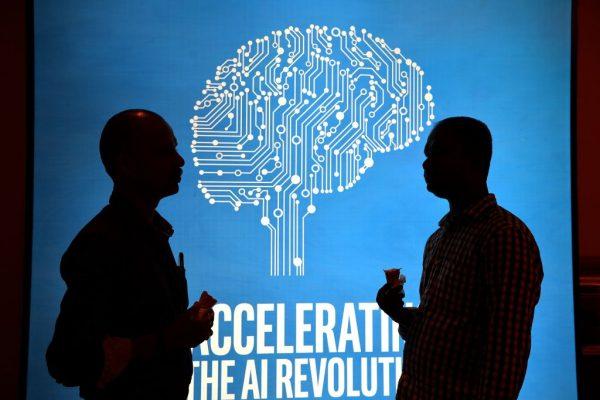 Participants at Intel's Artificial Intelligence (AI) Day stand in front of a poster during the event in the Indian city of Bangalore on April 4, 2017. (Manjunath Kiran/AFP/Getty Images)