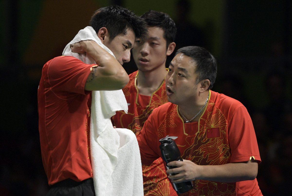 China's Zhang Jike, left, is counseled by his coach Liu Guoliang after losing a game in the men's team semi-final table tennis match against South Korea at the Riocentro venue during the Rio 2016 Olympic Games in Rio de Janeiro on Aug. 15, 2016. (Juan Mabromata/AFP/Getty Images)