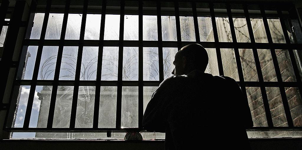A young inmate looks out from prison bars. (Photo by Peter Macdiarmid/Getty Images)