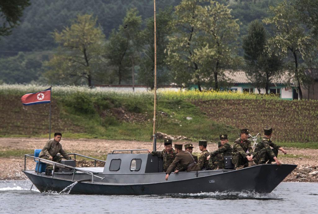 North Korean soldiers ride on a boat used as a local ferry. (Photo by Kevin Frayer/Getty Images)