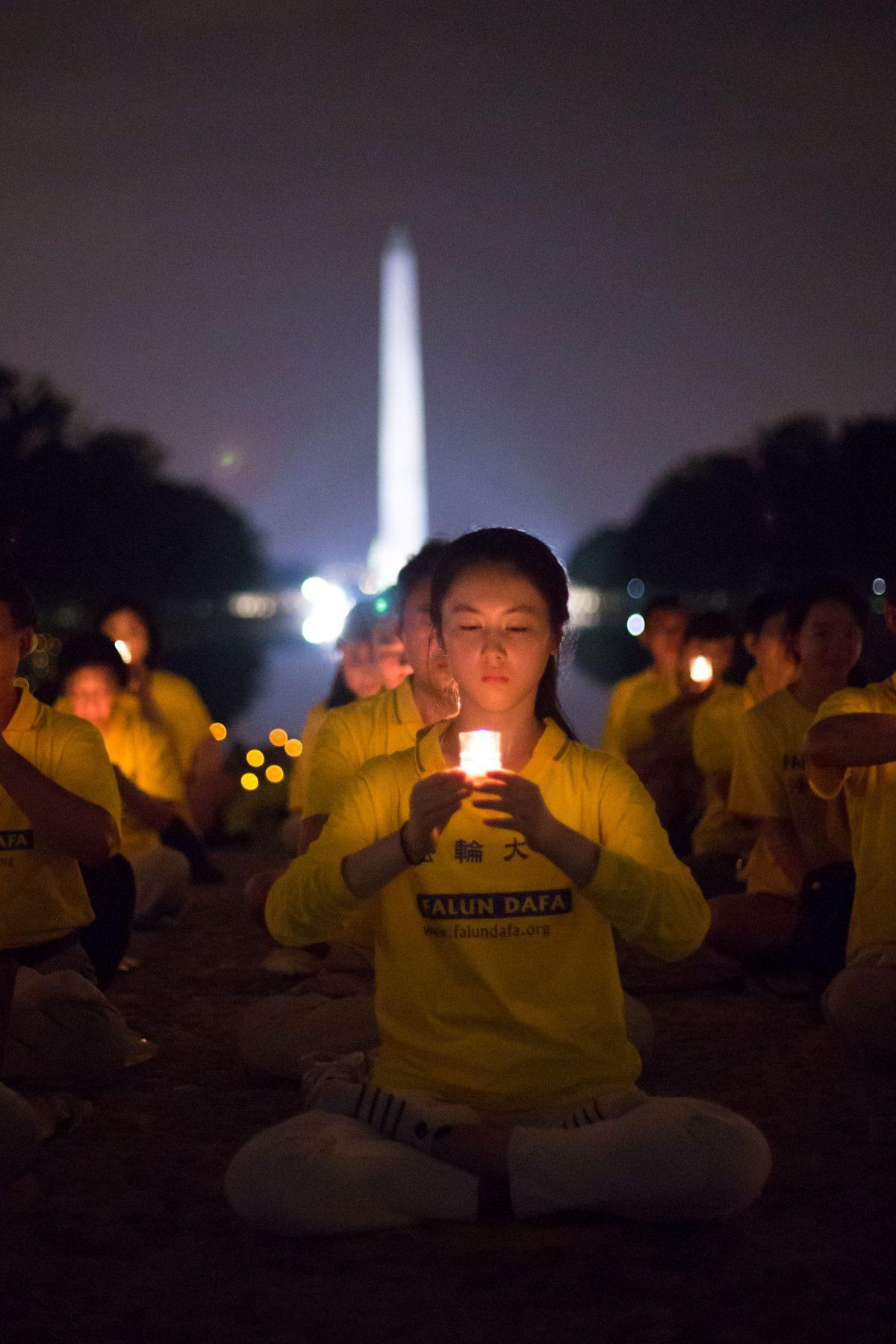 A woman joins Falun Gong practitioners in a candlelight vigil at the Lincoln Memorial in Washington on July 20, 2017, to honor those who have died during the persecution in China that the Chinese regime started on July 20, 1999. (The Epoch Times)