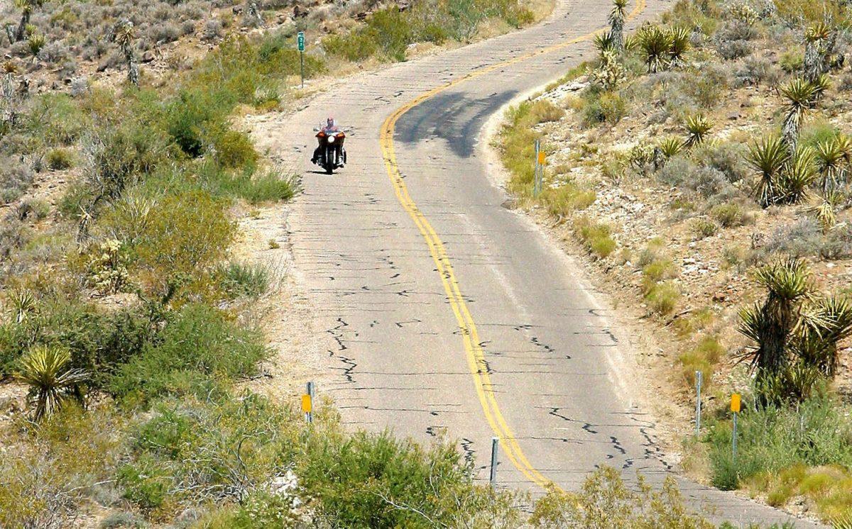 A lone motorcycle rider travels on historic Route 66 across the western Arizona desert on the approach to Oatman, Ariz., on July 12, 2003. (Robyn Beck/AFP/Getty Images)