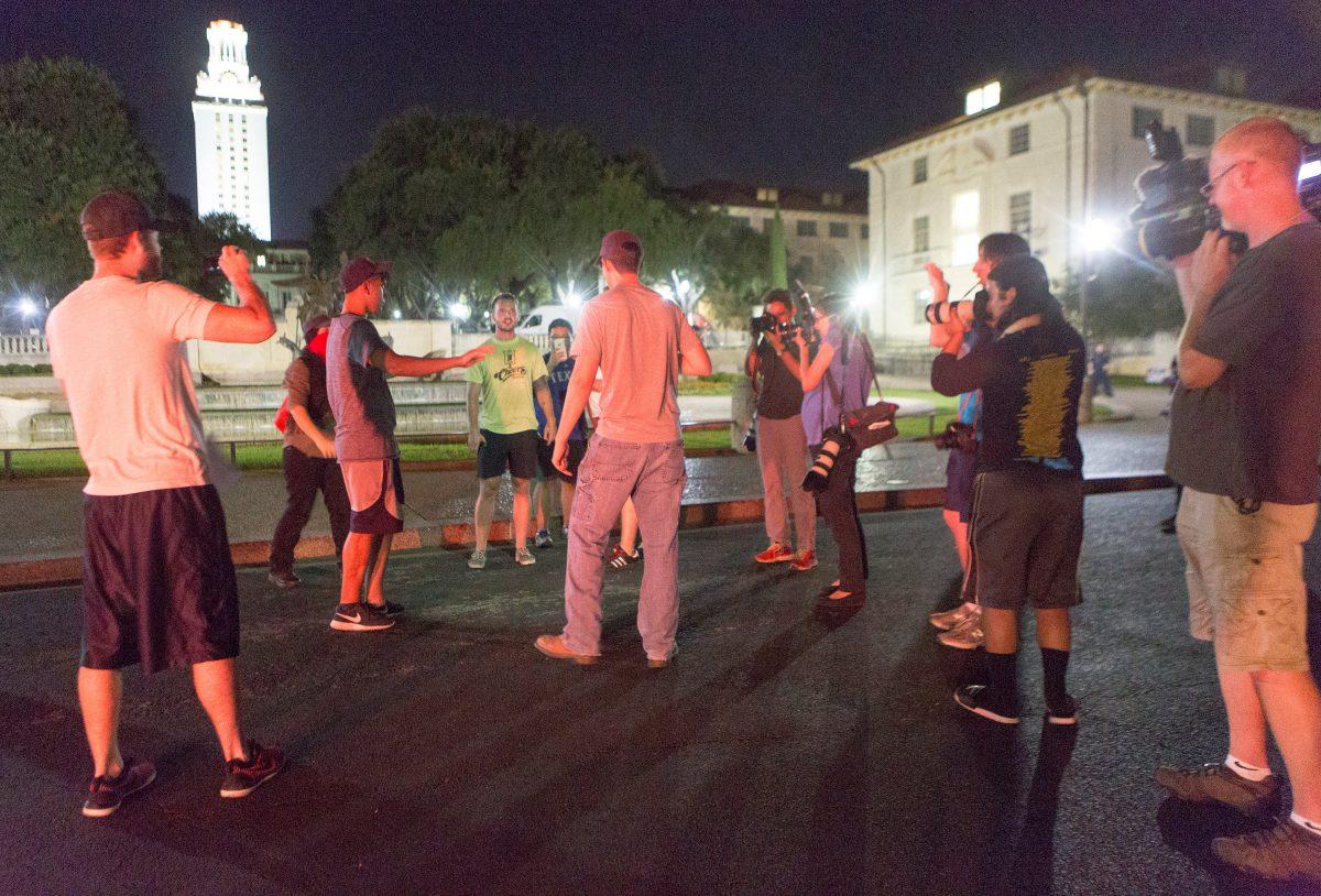 Onlookers share words as Confederate statues are removed from the south mall of the University of Texas in Austin, Texas, on Aug. 21, 2017. (Stephen Spillman/Reuters)