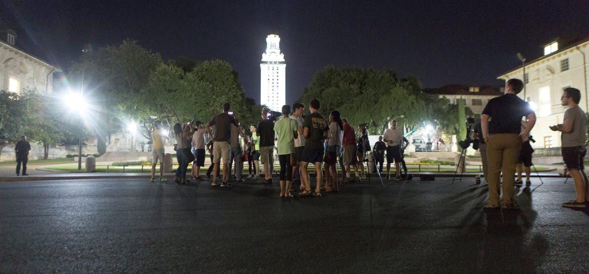 Onlookers watch as Confederate statues are removed from the south mall of the University of Texas in Austin on August 21, 2017. (Stephen Spillman/Reuters).