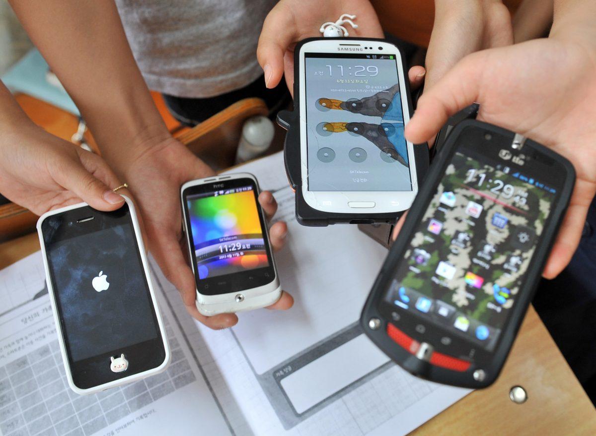 The brains of teenagers and children are especially vulnerable to app addiction. This picture taken on June 11, 2013 shows South Korean children displaying their smartphones after a special class on smartphone addiction at an elementary school in Seongnam, south of Seoul. (JUNG YEON-JE/AFP/Getty Images)