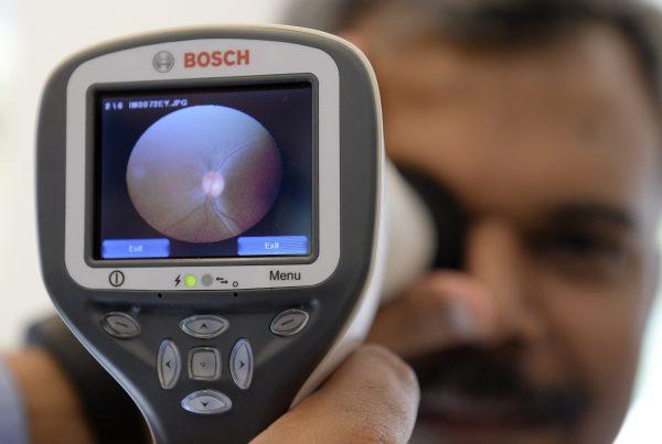 An employee of German technology company Bosch demonstrates the use of a Bosch eye care solution to check up the retina of an eye with a digital camera at the company's headquarters in Gerlingen near Stuttgart, southwestern Germany, on April 29, 2015. (THOMAS KIENZLE/AFP/Getty Images)