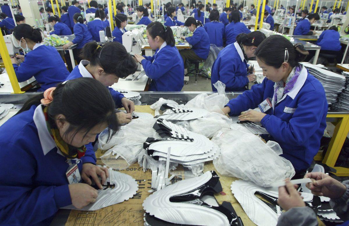North Korean women work at the assembly line of the factory of shoemaker Samduk Inc. at the Kaesong industrial complex in Kaesong, North Korea on Feb. 27, 2006. North Korean textile exports have plummeted since September. (photo by Chung Sung-Jun/Getty Images)