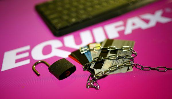Credit cards, a chain and an open padlock is seen in front of displayed Equifax logo in this illustration taken on Sept. 8, 2017. (Dado Ruvic/Illutration via Reuters)