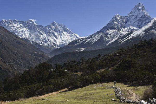 A Nepalese porter carries goods along a pathway in the Himalayas, with Mount Everest on the left, in the village of Tembuche in the Khumbu region of northeastern Nepal, on April 20, 2015. (Roberto Schmidt/AFP/Getty Images)