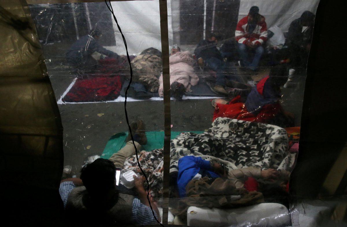 People sleep along the street next to a collapsed building as they wait for news of their loved ones after an earthquake in Mexico City, Mexico September 23, 2017. REUTERS/Henry Romero