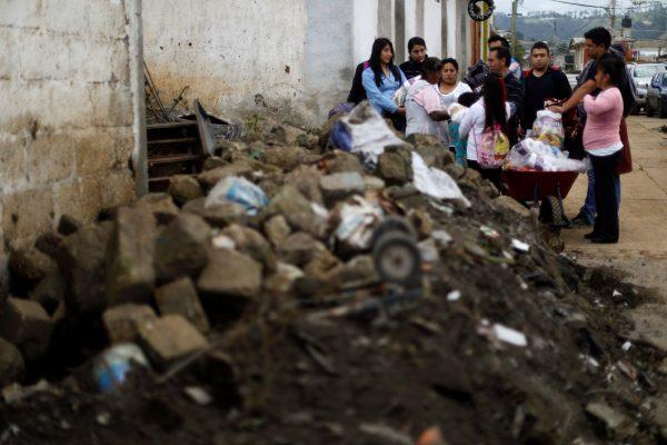 People stand behind rubble while handing out aid, after an earthquake, in San Simon el Alto, Mexico September 23, 2017. (Reuters/Edgard Garrido)