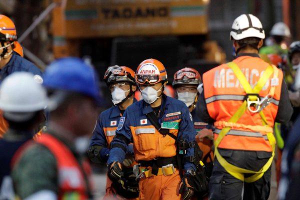 Members of a Japanese rescue team walk near the site of a collapsed housing unit, after an earthquake, in Mexico City, Mexico September 23, 2017. (Reuters/Daniel Becerril)