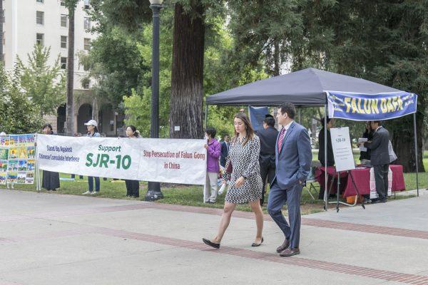 Falun Gong practitioners man a booth in front of the California State Capitol to raise awareness of SJR-10 being blocked by a Senate procedure. (Mark Cao/The Epoch Times)