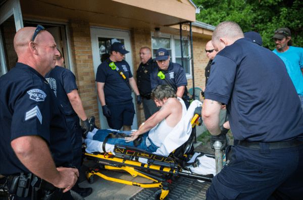 Local police, fire department, and deputy sheriffs help a man who is overdosing in Dayton, Ohio, on Aug. 3, 2017. (Benjamin Chasteen/The Epoch Times)