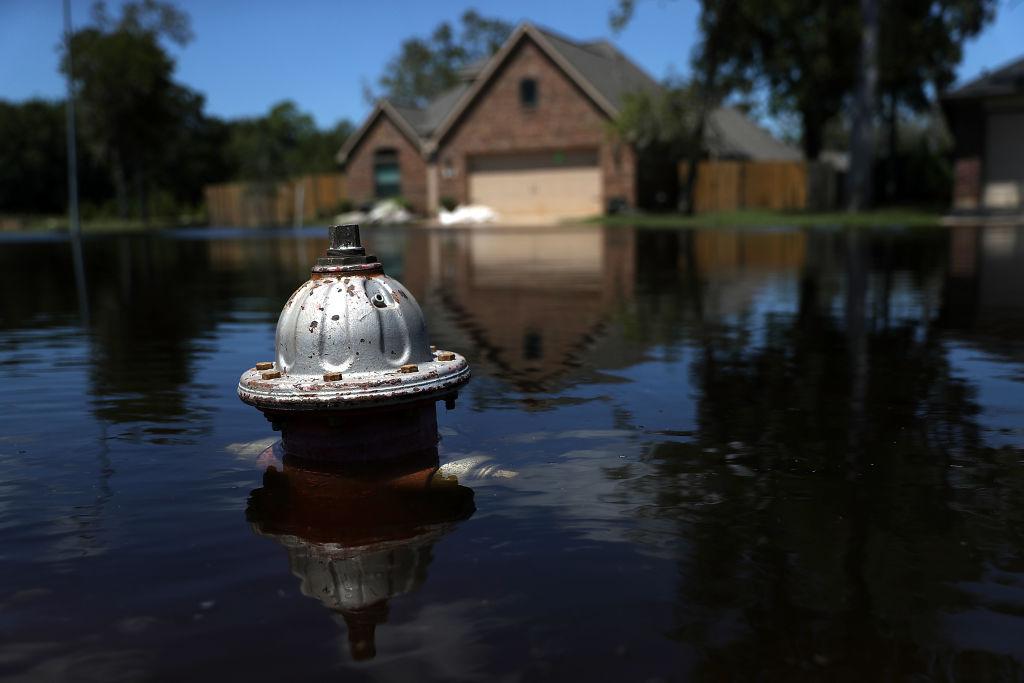 A hydrant sticks out of floodwaters in front of a home on in Texas. (Justin Sullivan/Getty Images)