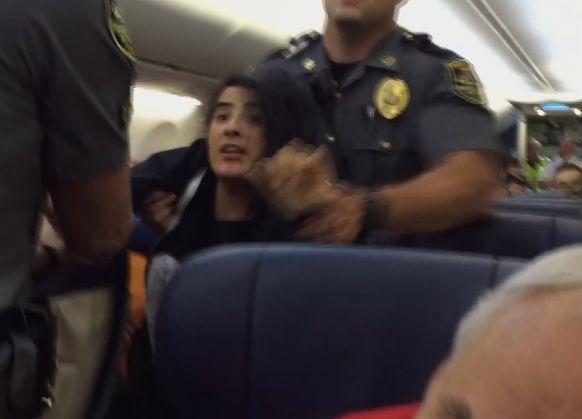 A video screenshot shows an unidentified woman being pushed off a Southwest Airlines plane (Screenshot/YouTube)