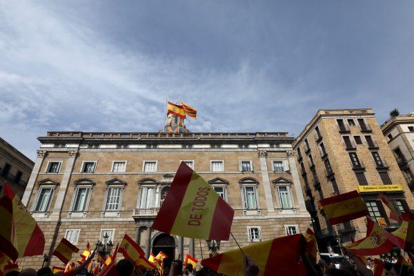 People hold up Spanish flags outside the Palau de la Generalitat, the regional government headquarters, during a demonstration in favor of a unified Spain a day before the banned October 1 independence referendum, in Barcelona, Spain, September 30, 2017. (Reuters/Susana Vera)