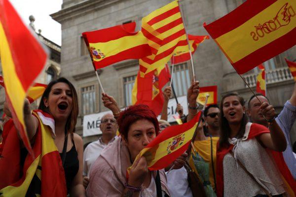 A woman kisses a Spanish flag as protesters hold Spanish and Catalan flags during a demonstration in favor of a unified Spain a day before the banned October 1 independence referendum, in Barcelona, Spain, September 30, 2017. (Reuters/Susana Vera)