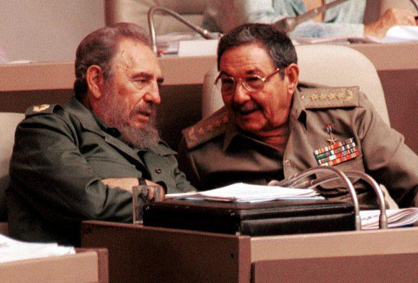 Cuban communist dictator Fidel Castro (L) speaks with brother Raúl in Havana on Aug. 3, 2001. (Jorge Rey/Getty Images)