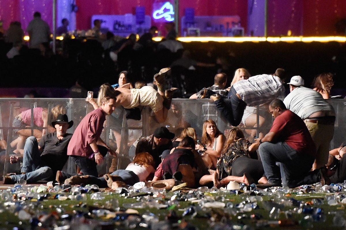 People scramble for shelter at the Route 91 Harvest country music festival after gunfire was heard in Las Vegas on Oct. 1, 2017. (Photo by David Becker/Getty Images)