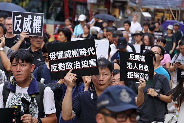 Protesters hold up signs with messages like, "don't fear the age of authoritarianism; against political persecution." (Cai Wenwen/The Epoch Times)