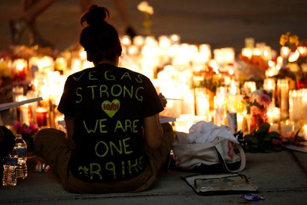 A woman makes a sign at a vigil on the Las Vegas strip following a mass shooting at the Route 91 Harvest Country Music Festival in Las Vegas, Nevada, U.S., October 2, 2017. REUTERS/Chris Wattie