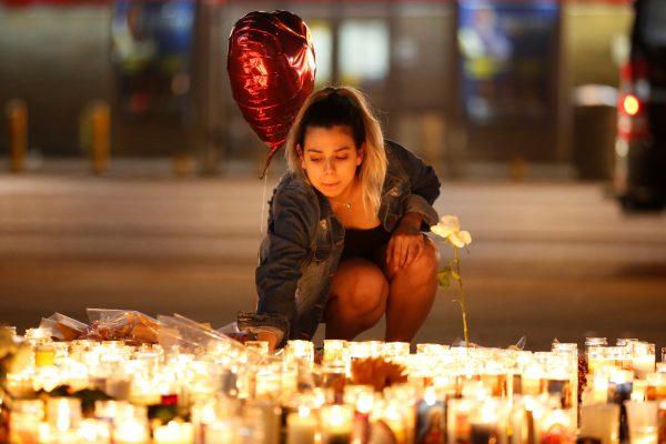 A woman lights candles at a vigil on the Las Vegas strip following a mass shooting at the Route 91 Harvest Country Music Festival in Las Vegas, Nevada, U.S., October 2, 2017. REUTERS/Chris Wattie