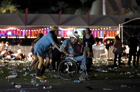 A woman helps a man escape during the Route 91 Harvest country music festival at the Las Vegas Village in Las Vegas on Oct. 1, 2017. (David Becker/Getty Images)