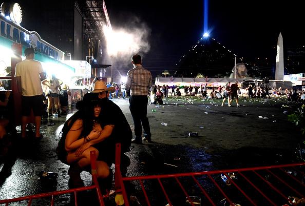 People take cover at the Route 91 Harvest country music festival after gunfire was heard in Las Vegas on Oct. 1, 2017. (David Becker/Getty Images)