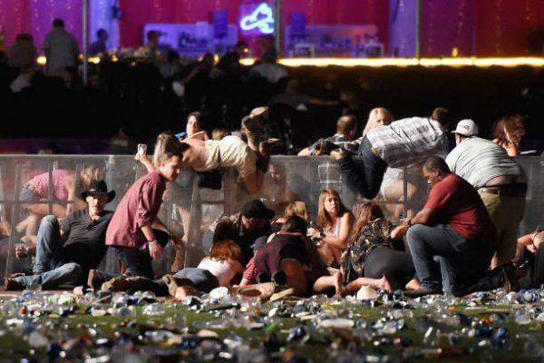 People scramble for shelter at the Route 91 Harvest country music festival after gunfire was heard in Las Vegas on Oct. 1, 2017. (David Becker/Getty Images)