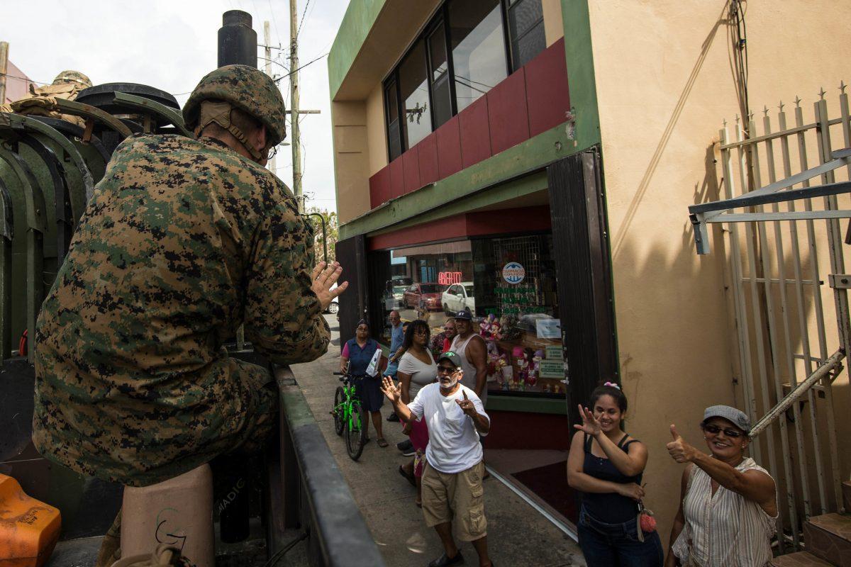 An officer with the U.S. Marine Corps waves to local residents during departure from Humacao Hospital after conducting a medical and operational needs assessment as part of Hurricane Maria relief efforts in Humacao, Puerto Rico, on Sept. 27, 2017. (U.S. Marine Corps/Lance Cpl. Tojyea G. Matally)