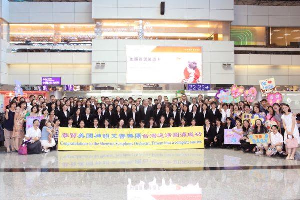 Fans take a group photo with members of the Shen Yun Symphony Orchestra at Taoyuan International Airport on Oct. 4, 2017. (Lin Shih-chieh/The Epoch Times)