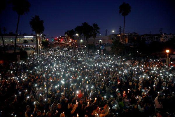 People hold candles and flashlights into the air during a memorial for Rachael Parker and Sandy Casey, Manhattan Beach city employees and victims of the October 1st Las Vegas Route 91 music festival mass shooting, in Manhattan Beach, Calif., on Oct. 4, 2017. (Reuters/Patrick T. Fallon)