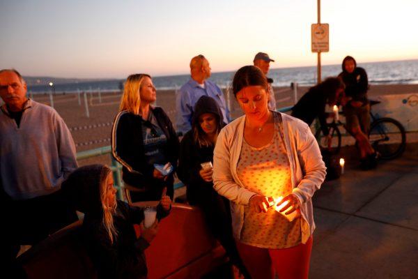 People light candles during a memorial for Rachael Parker and Sandy Casey, victims of the October 1st Las Vegas Route 91 music festival mass shooting, in Manhattan Beach, Calif., on Oct. 4, 2017. (Reuters/Patrick T. Fallon)