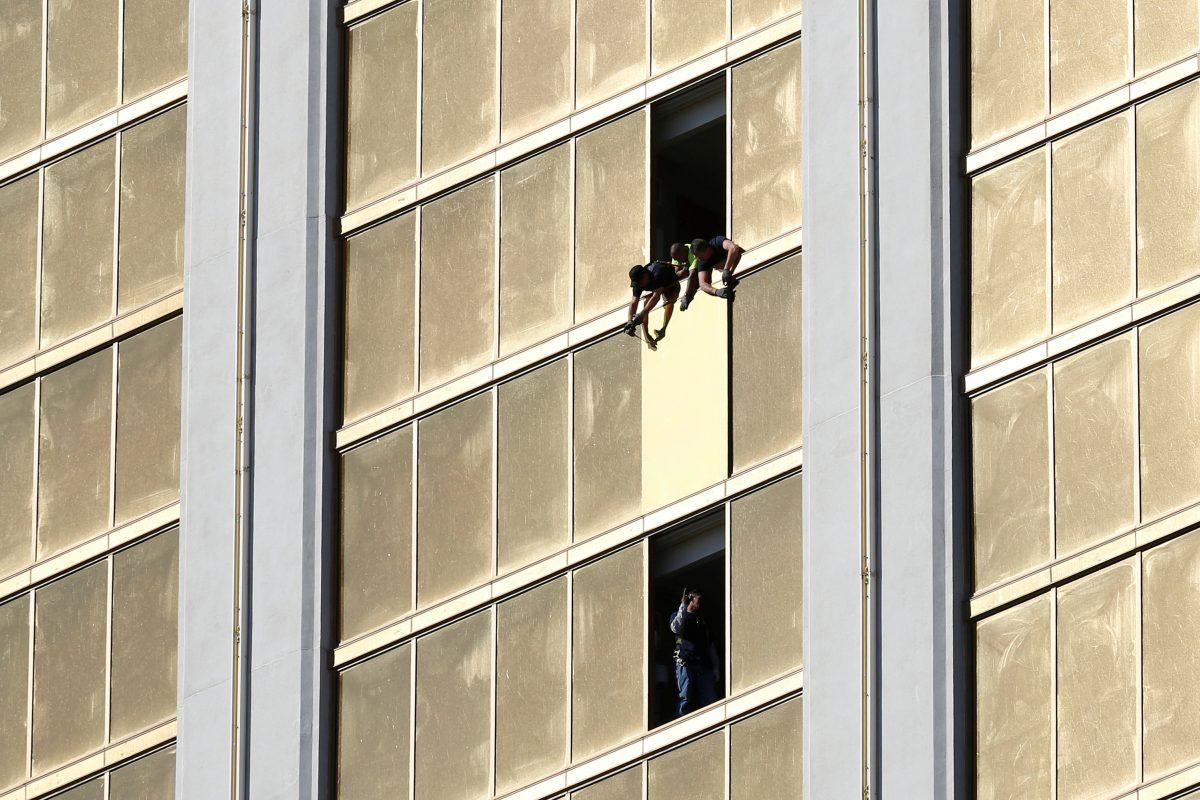 Workers board up a broken window at the Mandalay Bay hotel, where shooter Stephen Paddock conducted his mass shooting along the Las Vegas Strip on Oct. 6, 2017. Reuters/Chris Wattie