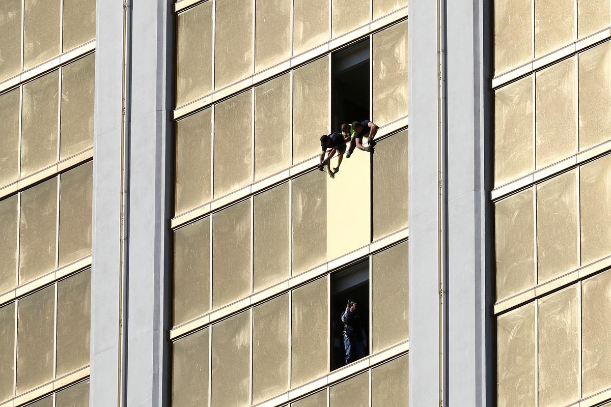 Workers board up a broken window at the Mandalay Bay hotel in Las Vegas on Oct. 6, 2017. (Reuters/Chris Wattie)