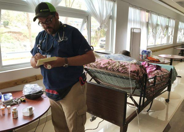 Dr. Carlos Mellado reviews prescriptions of patients in a public shelter in Orocovis, Puerto Rico, on October 3, 2017. (Reuters/Robin Respaut)