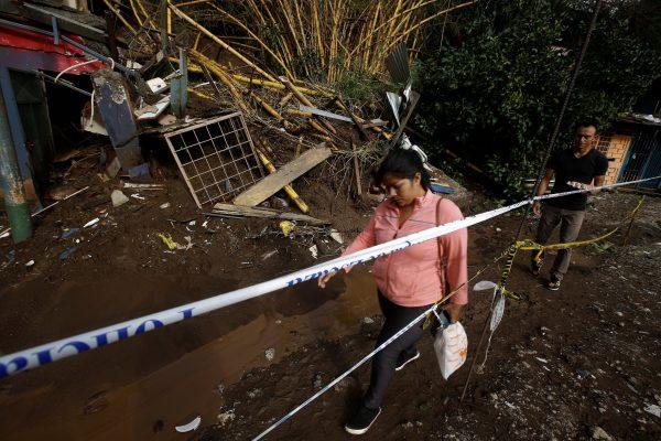 People walk near houses damaged by a mudslide after Storm Nate in the outskirts of San Jose, Costa Rica October 6, 2017. (Reuters/Juan Carlos Ulate)
