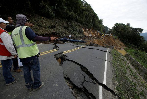 Workers of the National Emergency Commission check a highway that connects with the south of the country that was collapsed by Storm Nate in Casa Mata, Costa Rica October 6, 2017. (Reuters/Juan Carlos Ulate)