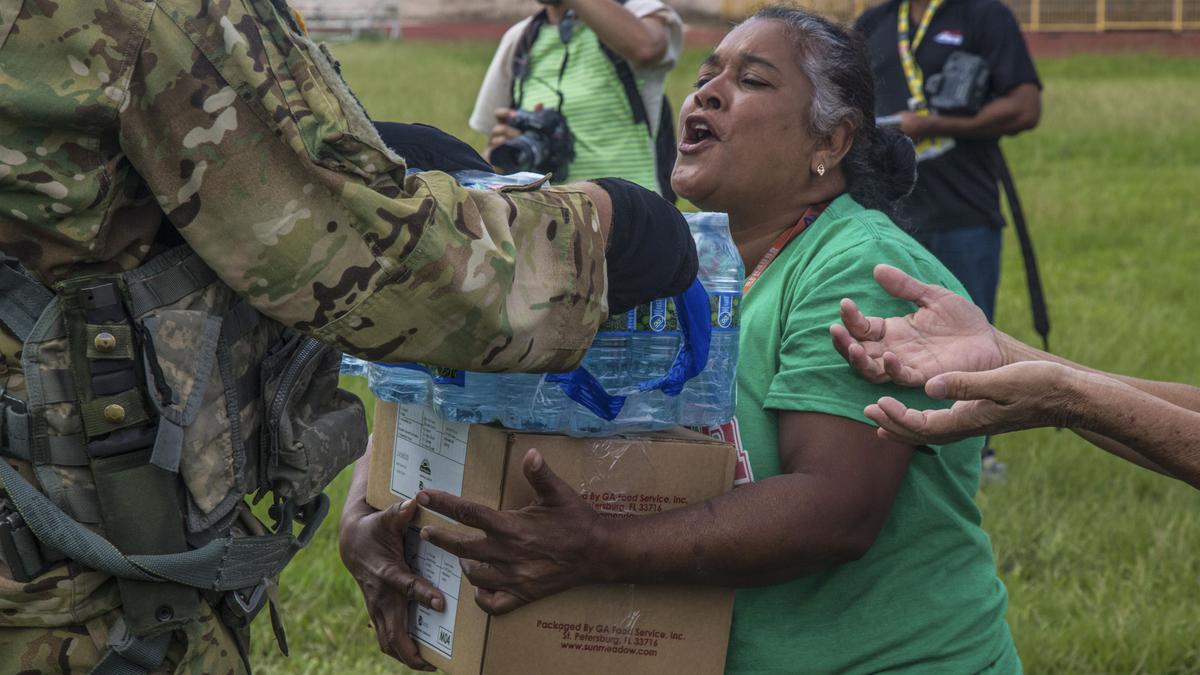 Soldiers hand boxes of food and bottled water to residents of Jayuga, Puerto Rico, Oct. 5, 2017. The soldiers are assigned to assigned to the 101st Combat Aviation Brigade, 101st Airborne Division's 101st Combat Aviation Brigade, which is conducting medical evacuation and relief efforts following Hurricane Maria. (Army photo by Staff Sgt. Pablo N. Piedra)