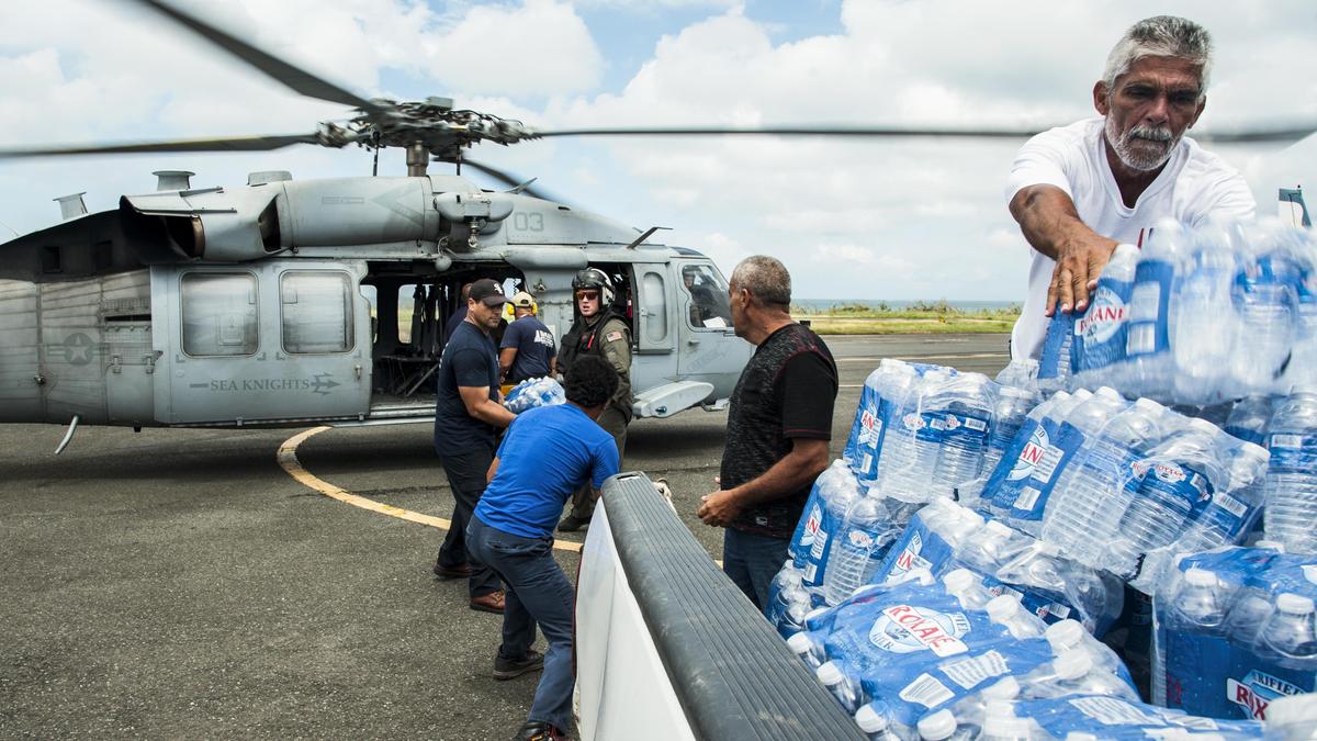 Sailors and emergency assistance responders transfer supplies off an MH-60S Seahawk helicopter in Villecas, Puerto Rico, on Oct. 5, 2017. The sailors are assigned to the USS Wasp, which is assisting with relief efforts following Hurricane Maria. (Navy photo by Petty Officer 3rd Class Levingston Lewis)