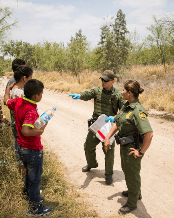 Border Patrol agents talk to a group of unaccompanied minors who crossed the Rio Grande from Mexico into the United States in Hidalgo County, Texas, on May 26, 2017. (Benjamin Chasteen/The Epoch Times)